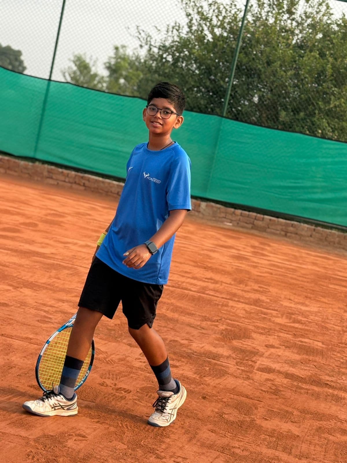 Junior player on clay court with racket